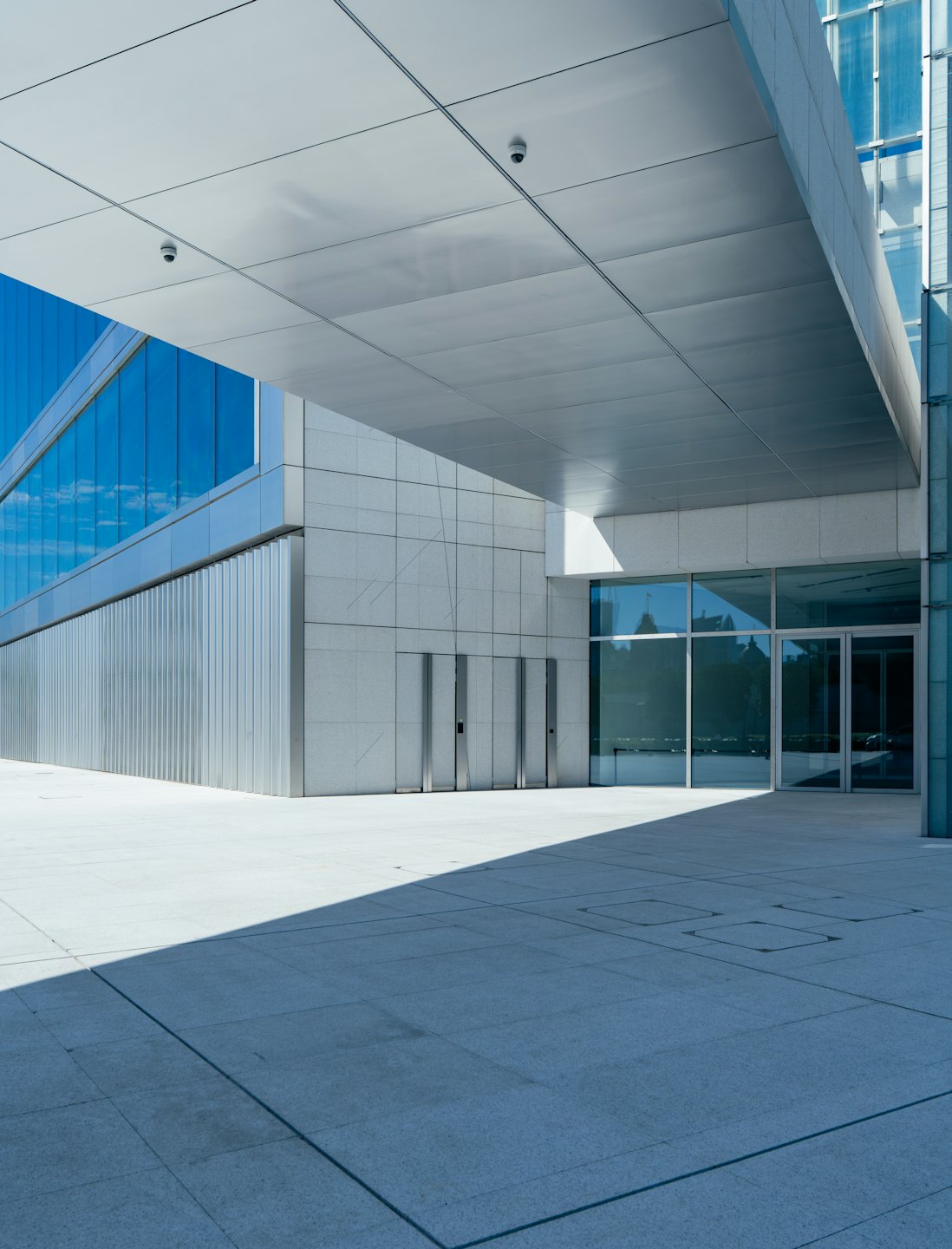 Modern building with blue glass windows and grey stone panels.